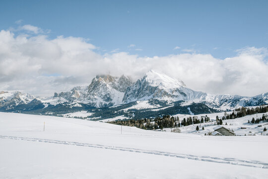 Blick von der Seiser Alm auf das Langkofelmassiv im Winter mit Skipisten und Langlaufloipen