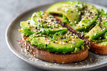 Sliced avocado on toast with sesame seeds on a plate