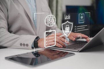 Fototapeta premium Professional businessman manages quality standards certification process via laptop computer showing digital icons representing ISO compliance security protocols document checklists data protection