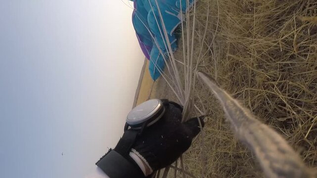 Parachutist landing in a field. Point of View.
