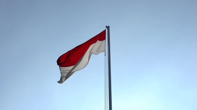 The single large red and white Indonesian flag flutters in the strong wind ahead of the 77th Independence Day of the Republic of Indonesia.	
