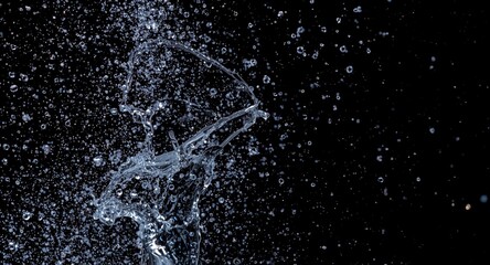 Obraz premium Dynamic water splash captured on a dark black background texture