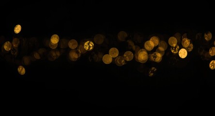 Obraz premium Black canvas with sparkling golden light bokeh effects in landscape layout and copy space for occasion greetings