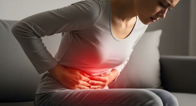 Abdominal pain and digestive system disorders. Stomach health and internal medicine. Woman sitting on a sofa holding her painful stomach with red inflammation glow