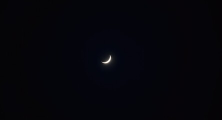 Bright lunar crescent illuminating a serene deep navy dark sky