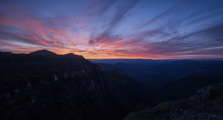 Obraz premium colorful dawn sky reflecting on rugged mountain slopes