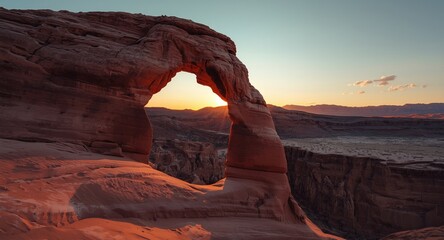 Evening light highlighting the curves of a natural arch in desert terrain