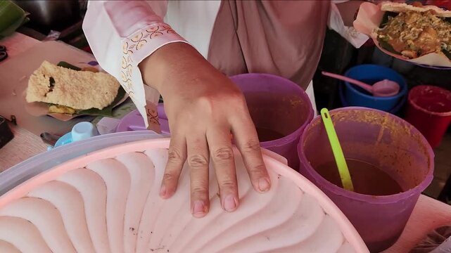Freshly prepared pecel with traditional Indonesian ingredients. Street vendor serving delicious and healthy pecel dish. A vendor creating fresh Indonesian pecel for hungry customers. 