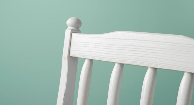 Closeup selective focus of white Caribbean style wood backrest on a soft mint green background