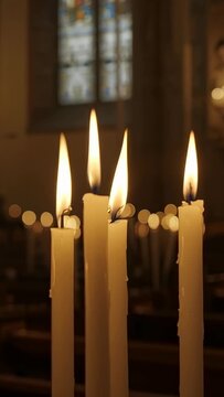 Vertical video: Flickering while camera rolling, five taper candles dripping wax in church, votives