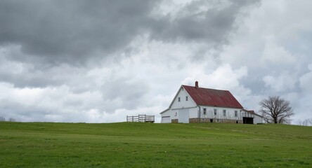 Obraz premium A white farmhouse and stone barn share a bright hillside with overhanging dark clouds