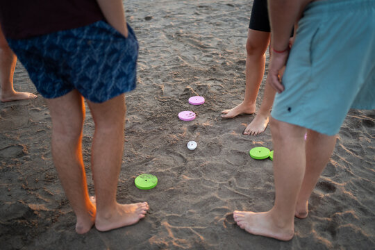 People playing traditional tejo beach game on sand