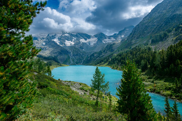 Naklejka premium Majestic alpine lake amidst snow-capped mountains and lush forest