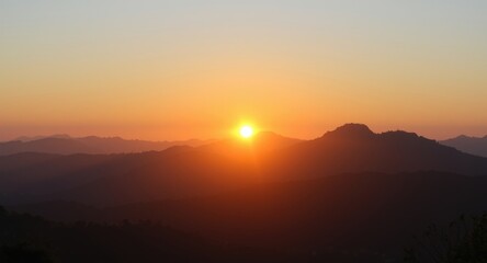 Obraz premium Sunrise panorama showcasing sunlit mountain tops in warm morning light