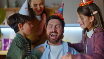 Fototapeta premium Birthday man blowing candles on cake making wish at celebration at home closeup