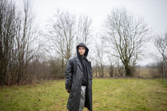 A man in a black leather coat in gloomy weather outdoors in an emotional crisis and sadness