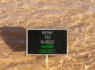Naklejka premium How to build good credit symbol. Concept words How to build good credit on beautiful black blackboard. Beautiful sea water background. Business how to build good credit concept. Copy space.