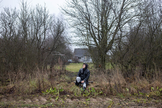 A man is sad while sitting on a bench in nature. Crisis and loneliness in a man's life.