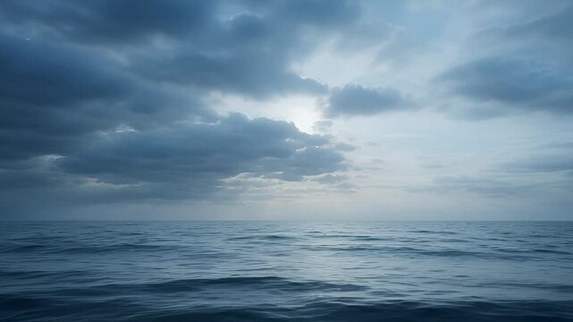 Overcast Sky With Sun Rays Breaking Through Dark Clouds Over a Rippling Ocean