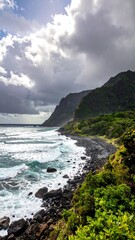 Fototapeta premium Rocky shoreline curves towards tall green cliffs beneath stormy skies over ocean