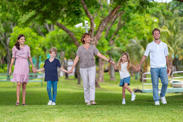 Fototapeta premium Happiness family outdoor joyful enjoying nature bonding in nature intergenerational happiness. Multigenerational family walking in park outdoor fun lifestyle relaxing smiling walking connection
