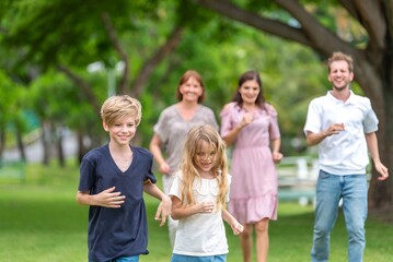 Fototapeta premium Happiness family outdoor joyful enjoying nature bonding in nature intergenerational happiness. Multigenerational family walking in park outdoor fun lifestyle relaxing smiling walking connection