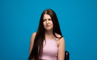 Naklejka premium Young woman expressing disgust, a grimace of dislike and skepticism on her face, disapproval concept