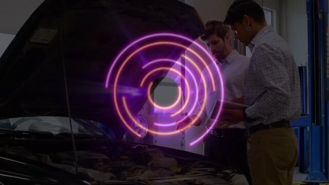Abstract neon circle over caucasian auto mechanic discussing about car with coworker in repair shop