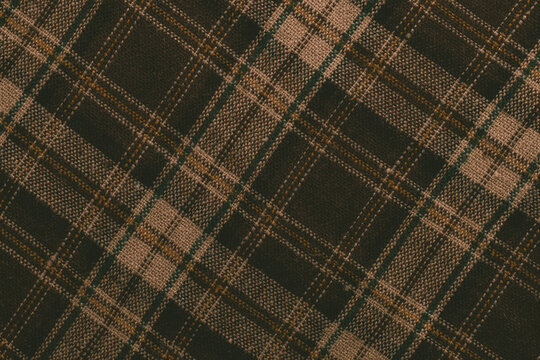 Pattern of brown and green plaid fabric created with woven yarn at a close range