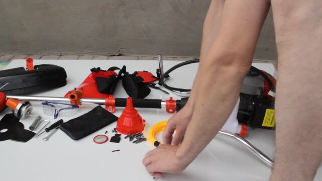 Assembling the shaft of a petrol brushcutter, Assembly of garden equipment, Preparation for the mowing season, Professional brushcutter equipment before assembly