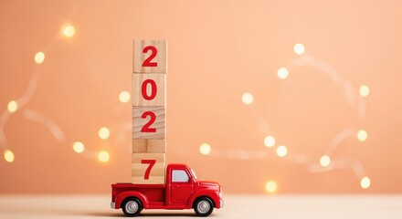 Red toy truck with wooden block numbers 2027 on peach background with string lights