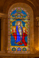Naklejka premium Stained glass window depicting Assumption of Mary with angels
