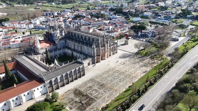 Drone flight above Batalha Monastery revealing town streets and rooftops