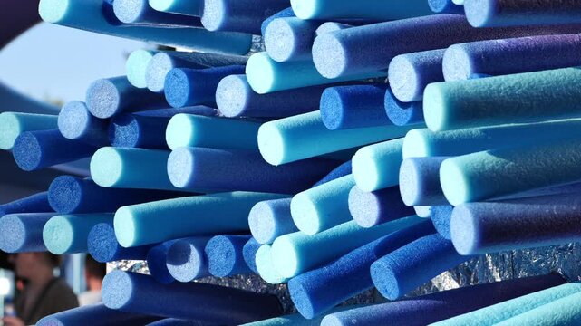 Blue pool noodles abstract art installation creating a vibrant textured pattern