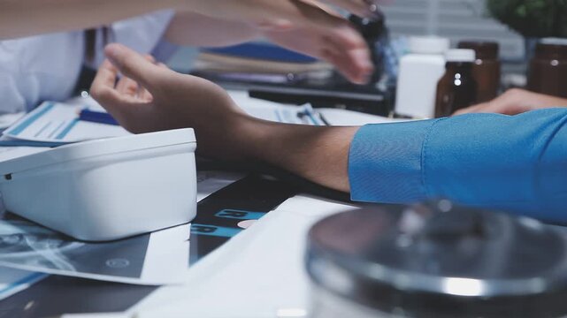 Doctor using stethoscope take a tap on the patient's arm and pressing pressure gauge button.
