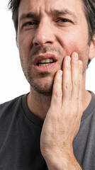 Naklejka premium Macro photo of the mouth and lower face of a man with a toothache caused by gum problems and inflammation, grimacing in pain and holding his jaw with his hand, isolated on white background