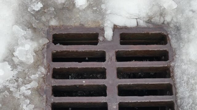 Cast iron drainage grate during snow melting close-up