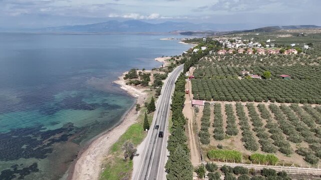 Drone flying along coastal road by Aegean Sea near Didim Turkey