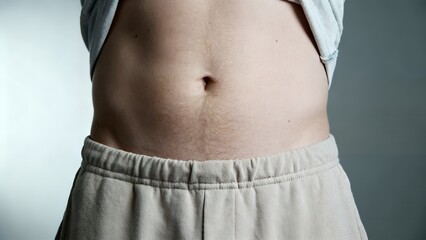 Close-up of a bare midriff showing navel and casual elastic-waist pants