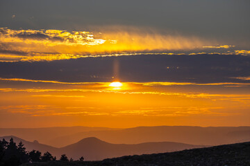 Obraz premium Golden sun setting over layered mountains in Navarra, Spain