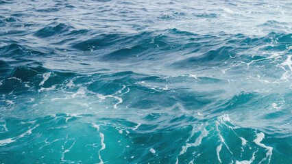 Obraz premium Turquoise ocean surface with gentle ripples and foam.