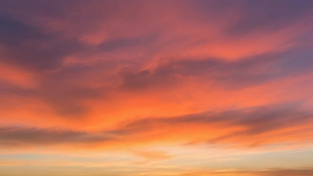 dramatic colorful clouds glowing during sunset, orange and pink sky slowly changing colors, peaceful atmospheric background, static camera, ultra realistic, 4k, 5 seconds, stable footage, clean footag