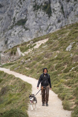 Fototapeta premium Woman and husky dog hiking mountain trail