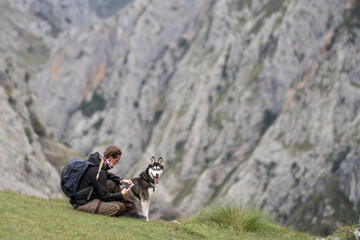 Woman with husky dog using phone hiking mountains © OscarStock