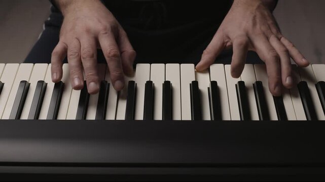 Close-up of beginner pianist, male hands practicing on a electronic piano keyboard