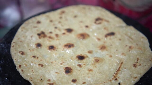 Traditional flatbread paratha cooking on a hot tawa
