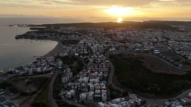 Aerial Drone Flying Backward Revealing Didim City at Sunset on Aegean Coast