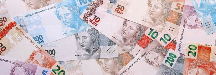 Obraz premium Brazilian real money bills pile on table. Brazil banknotes of BRL currency close up.
