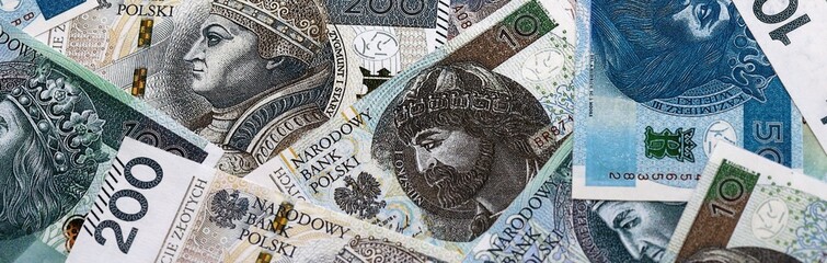 Polish zloty money bills pile on table. Poland banknotes of PLN currency close up.