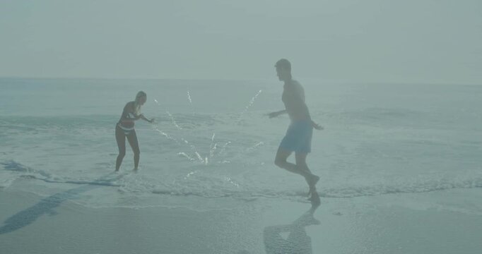 Woman and man reacting to spark, backing playful hopping circling stepping through surf travel